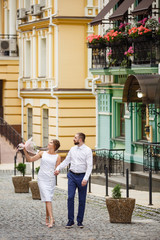 Young Bride and Groom couple in summer old City garden. Tender holding each other. woman and man couple. Romantic walk of young happy family near hydrangea bush. lovers newlyweds street style wedding