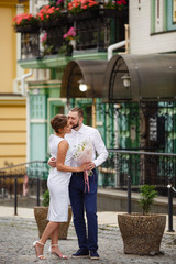 Young Bride and Groom couple in summer old City garden. Tender holding each other. woman and man couple. Romantic walk of young happy family near hydrangea bush. lovers newlyweds street style wedding