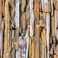 background texture-mosaic of weathered wood, granite, quartzite and shale rock on an outdoor walkway