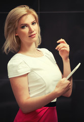 Fototapeta premium Young blond fashion woman using a tablet computer