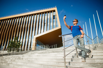 A male student or graduate student taking selfie near a modern university. Innopolis, Kazan.