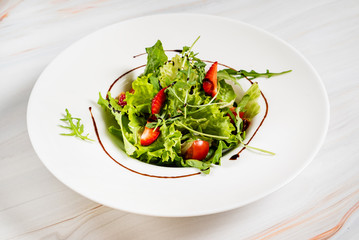 healthy salad with strawberriesa and arugula