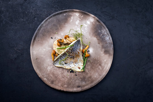 Gebratenes Gourmet Dorade Filet mit aufgeschnittenen Kn&ouml;del, Queller und Algen als Draufsicht auf einem Modern Design Teller mit Textfreiraum