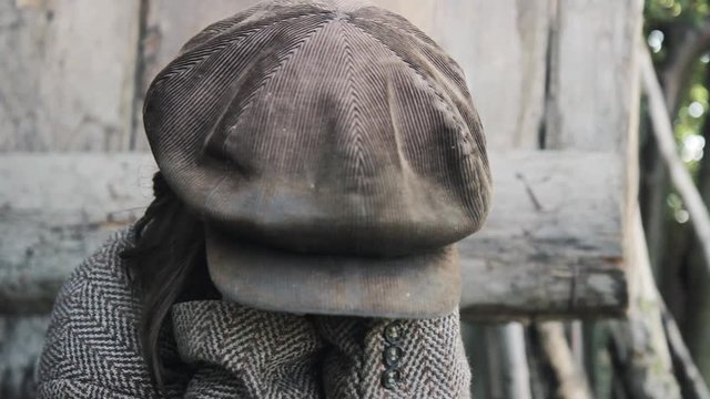 poor orphan girl in old clothes looking at camera