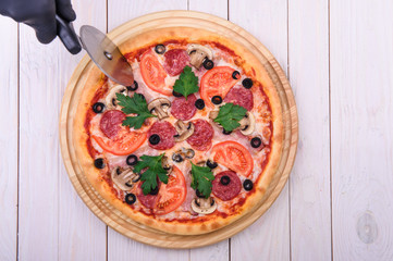 pizza with sausage tomato mushrooms and olives on a white background