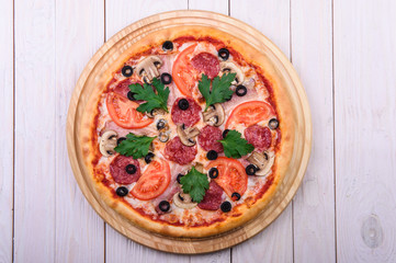 pizza with sausage tomato mushrooms and olives on a white background