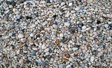 Background of multi-colored pebbles on the shore.