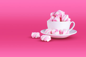 Fototapeta na wymiar Pink marshmallows background in a white cup, dessert pastel tones, sweet dishes. Background or texture of colorful mini marshmallows