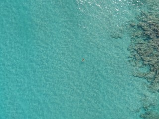 Young man swimming front crawl in sea aereial view 
