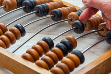 Vintage abacus closeup. Accountant at work with a pen in his hand.