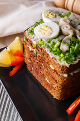 a huge herring sandwich with mayonnaise and quail eggs