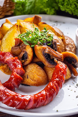 baked potatoes with sausages on a wooden rustic background