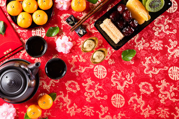 Chinese new year festival decorations pow or red packet, orange and gold ingots or golden lump on a red background. Chinese characters FU in the article refer to fortune good luck, wealth, money flow.