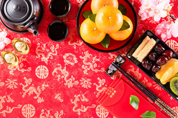 Chinese new year festival decorations pow or red packet, orange and gold ingots or golden lump on a red background. Chinese characters FU in the article refer to fortune good luck, wealth, money flow.
