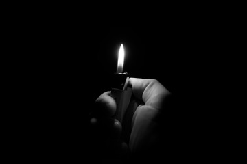 Hand holding lighter in the dark