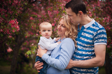 Fototapeta premium happy family mother, father, little son for a walk in the summer park.Happy young family spending time together, outside, on vacation, outdoors. The concept of family holiday.