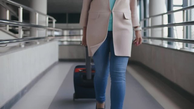 Aged lady running and dragging suitcase being late for train or flight