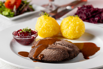 closeup of a german sauerbraten with dumplings