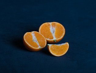 Still life of Clementine's tangerine in a section on a dark blue background