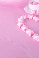 Pink marshmallows colorful background. Dessert pastel colors, sweet dishes. Background or texture of colorful mini marshmallows