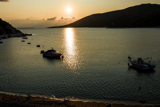 Boats parking in the Mediterranean sea bay, golden light scenery during morning sunrise