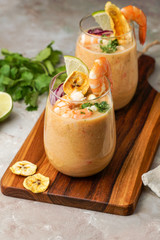 leche de tigre, Peruvian,  Ecuador, Latin American food, raw fish cocktail ceviche with lime, aji limon and cilantro. Traditional peruvian food with srimps and banana chips