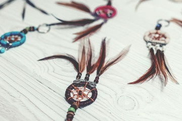 Ethnic dreamcatchers on a wooden background. Dream catchers, indian amulet, feathers, decoration.