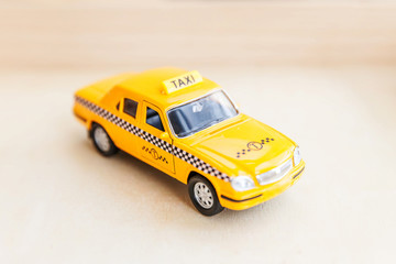 Simply design yellow vintage retro toy car Taxi Cab model on wooden background. Automobile and...