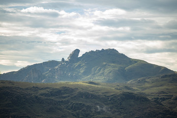Itacolomi mountain top in Ouro Preto, Brazil, against an overcast hazy and cloudy sky with patches...