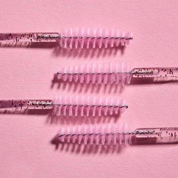 Minimalism brush for combing eyelashes on pink background. beauty fashion.Patern