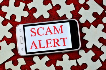 Fraud alert-a message on the smartphone screen. Fraud is the theft or acquisition of the right to...