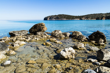 Fototapeta na wymiar Beautiful idyllic turquoise waters coast with pebbles and rocks.