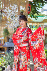 The girl is wearing a red traditional kimono, which is the national dress of Japan
