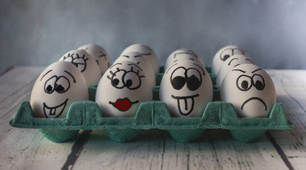 White eggs with painted faces in the shell