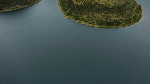 Aerial tilts up at Cuicocha Lake during a foggy morning. Otavalo, Ecuador.