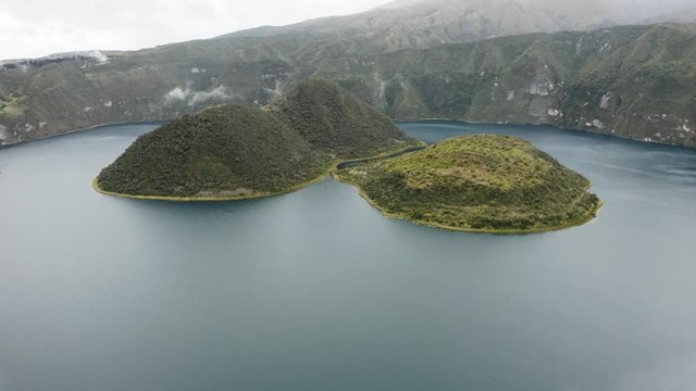 Aerial flies backwards into Fog. Islands of Cuicocha during morning.