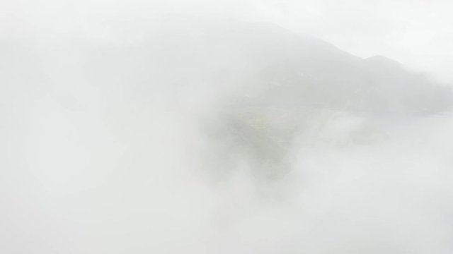 Aerial flies through fog, revealing the Islands of Cuicocha during morning. Otavalo, Ecuador.