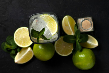 process of making homemade cocktail, flat with the ingredients for mojito on a black background, a refreshing summer cocktail