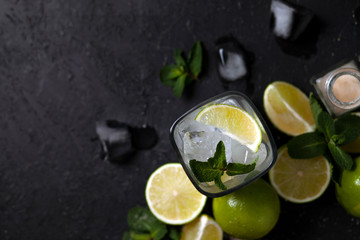 Fototapeta premium process of making homemade cocktail, flat with the ingredients for mojito on a black background, a refreshing summer cocktail