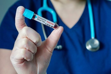Nurse holding a positive blood test result for the new rapidly spreading Coronavirus, originating...