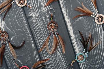Ethnic dreamcatchers on a black wooden background. Dream catchers, indian amulet, feathers, decoration.