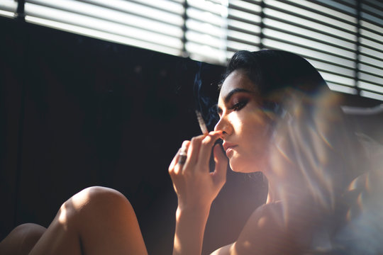 Attractive sexy woman thin  sexy girl Glamour women long hair slim body gets topless got cigarette 