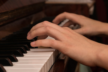Obraz premium Hands of a girl playing the piano close-up
