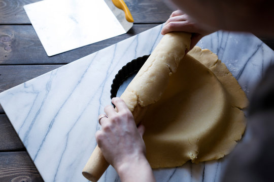 Step-by-step photo for rolling tart dough into a tart pan.