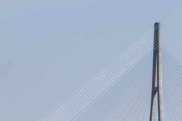 Horizontal photo of a pylon bridge against a pale blue sky