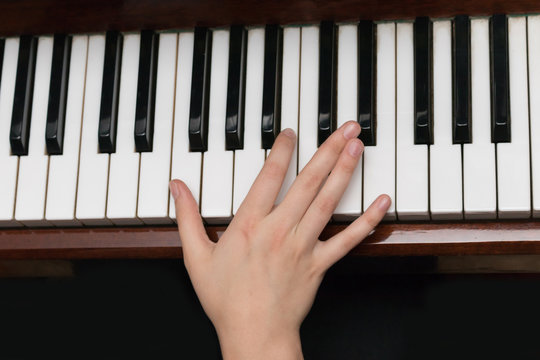 Right hand of a girl playing the piano close-up