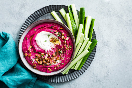 Pink beet cashew hummus swirled with garlic yogurt tahini and sprinkled with roasted almond za&rsquo;atar.