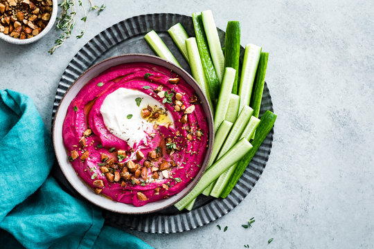 Pink beet cashew hummus swirled with garlic yogurt tahini and sprinkled with roasted almond za&rsquo;atar.