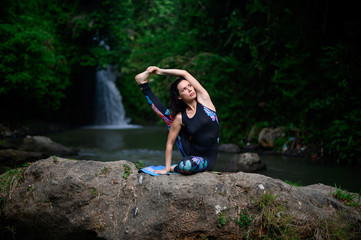 Yoga practice and meditation in nature. Woman practicing near river