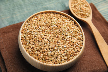 Uncooked green buckwheat grains on table, closeup